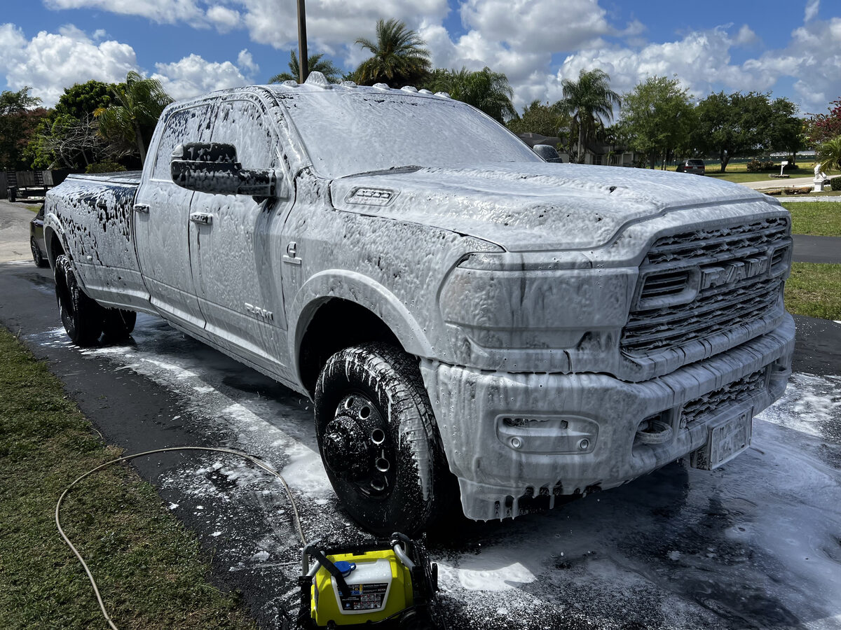 Black RAM dually truck covered in foam during mobile detailing pre-wash